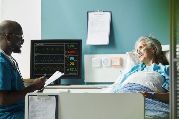 Middle aged black male doctor consulting senior caucasian female patient