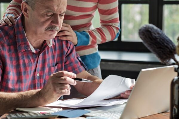 Serious mature hispanic man man checking home finance calculating money