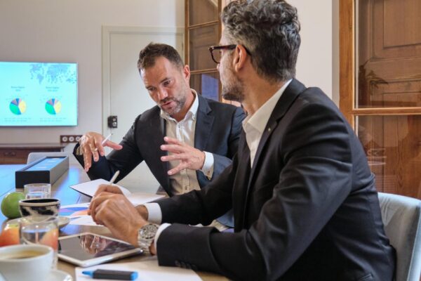 Focused businessmen sitting and having conversation about project while collaborating in office
