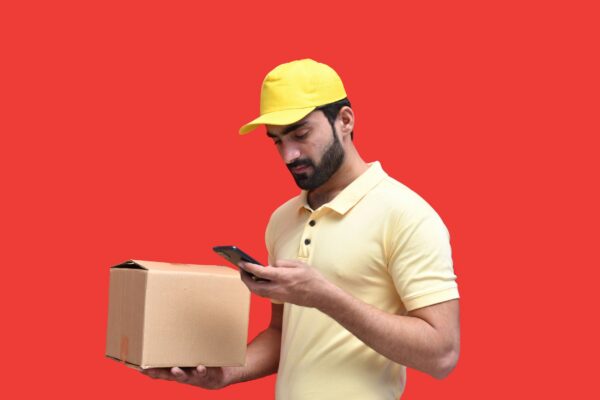 a man in a yellow hard hat looking at a phone