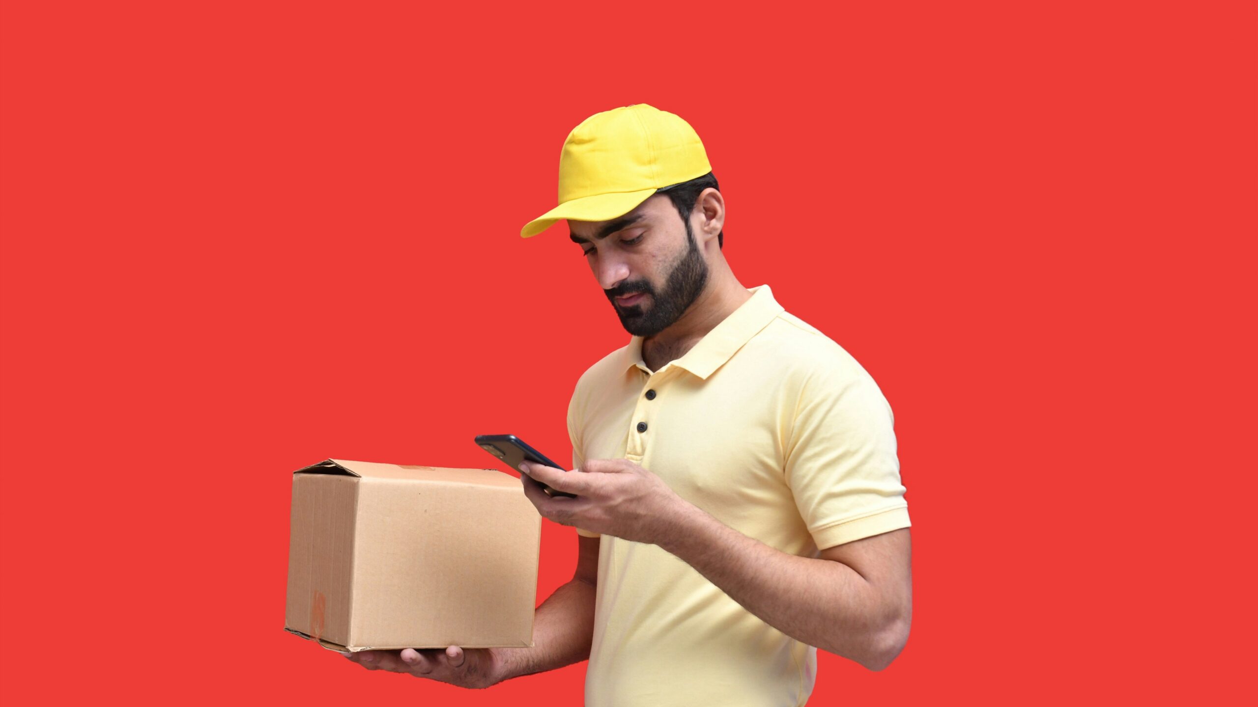 a man in a yellow hard hat looking at a phone