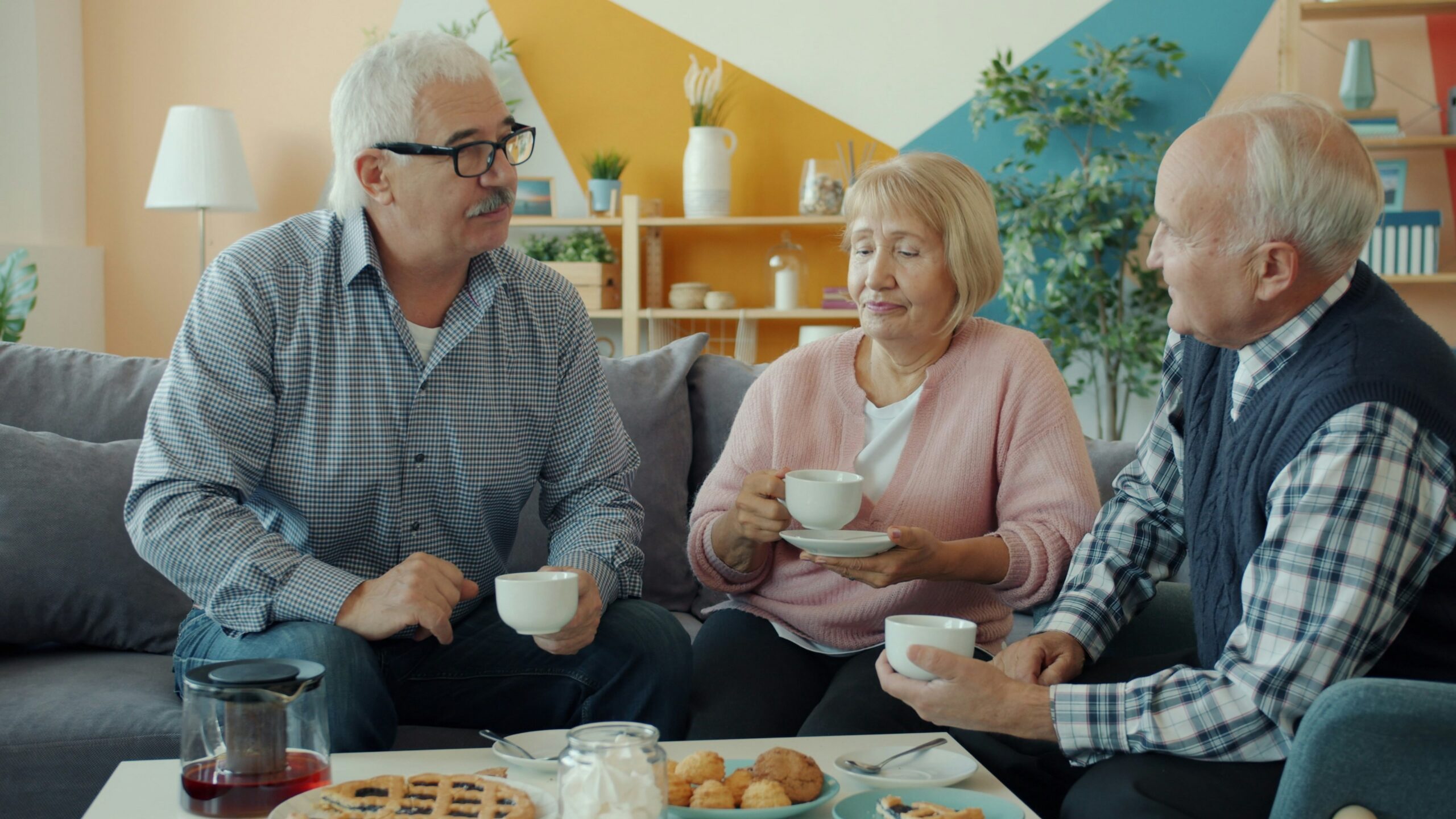 Three seniors enjoying coffee and conversation at home.