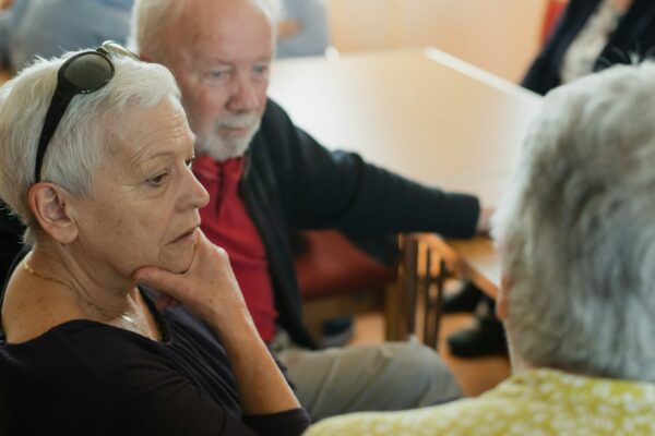 Elderly people are sitting and talking with each other.