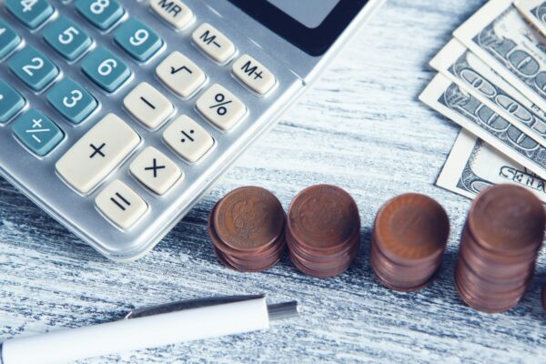 a calculator, pen, and money on a table