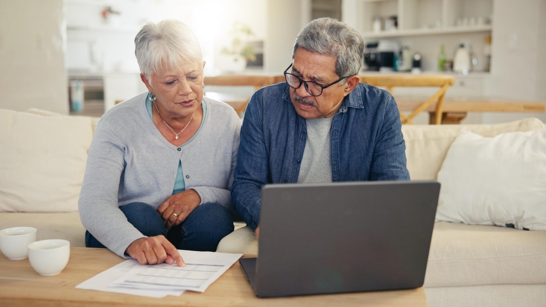 Elderly couple and laptop with document for financial planning investment or paperwork for retirement Senior man woman and tech with budget for online banking account or savings in home