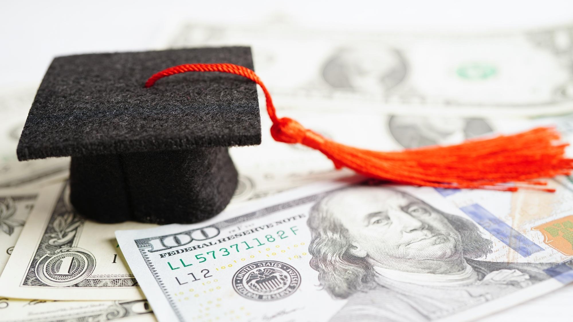 Graduation gap hat on US dollar banknotes money Education study fee learning teach concept