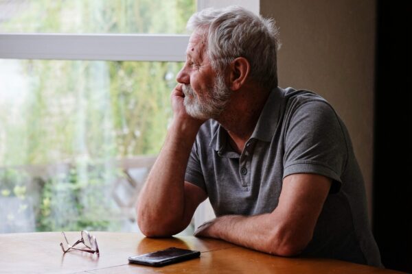 Senior retired man sitting at home alone while quarantine