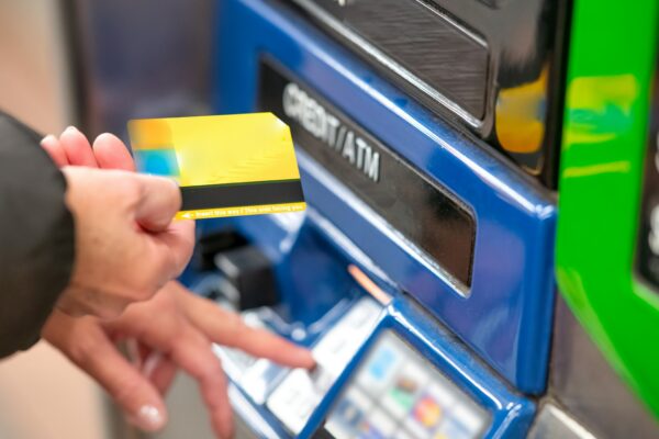 a person using a credit card to pay for a machine