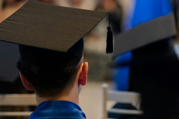 A man in a graduation cap sitting in a chair