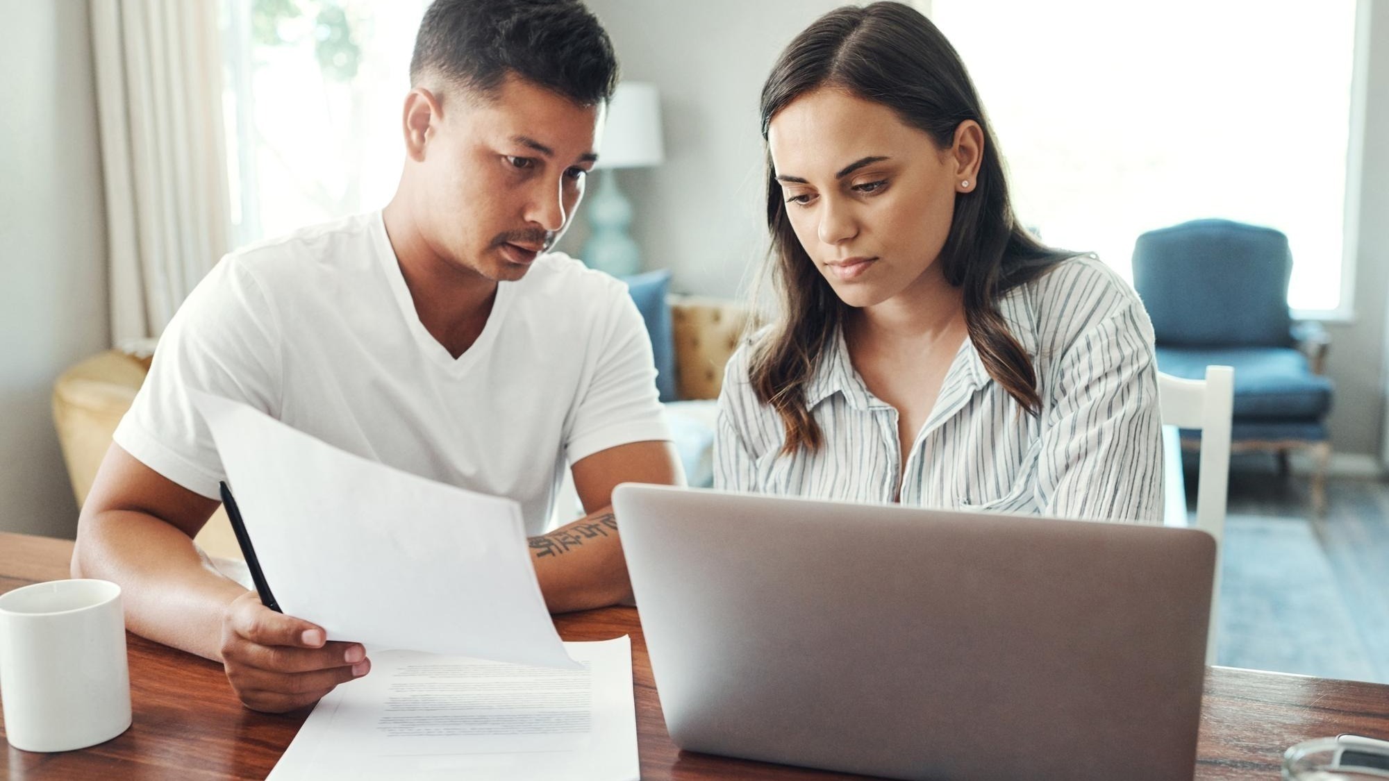 Couple conversation and paperwork with laptop in home for asset management savings fund and budget review Computer man and woman with mortgage research financial discussion and documents for tax