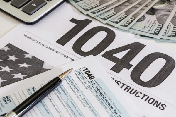 tax forms 1040 and calculator with dollars