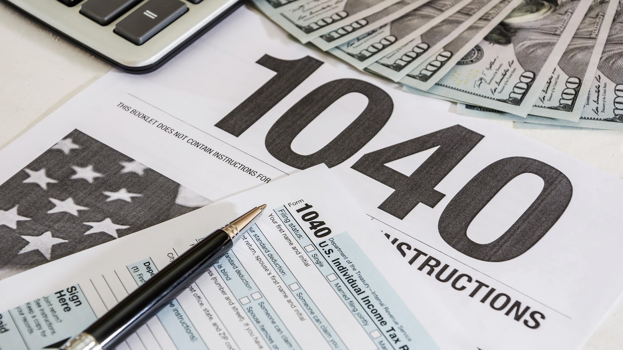 tax forms 1040 and calculator with dollars