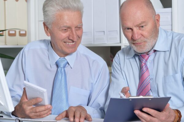 Portrait of two senior Business people working together with computer on the table