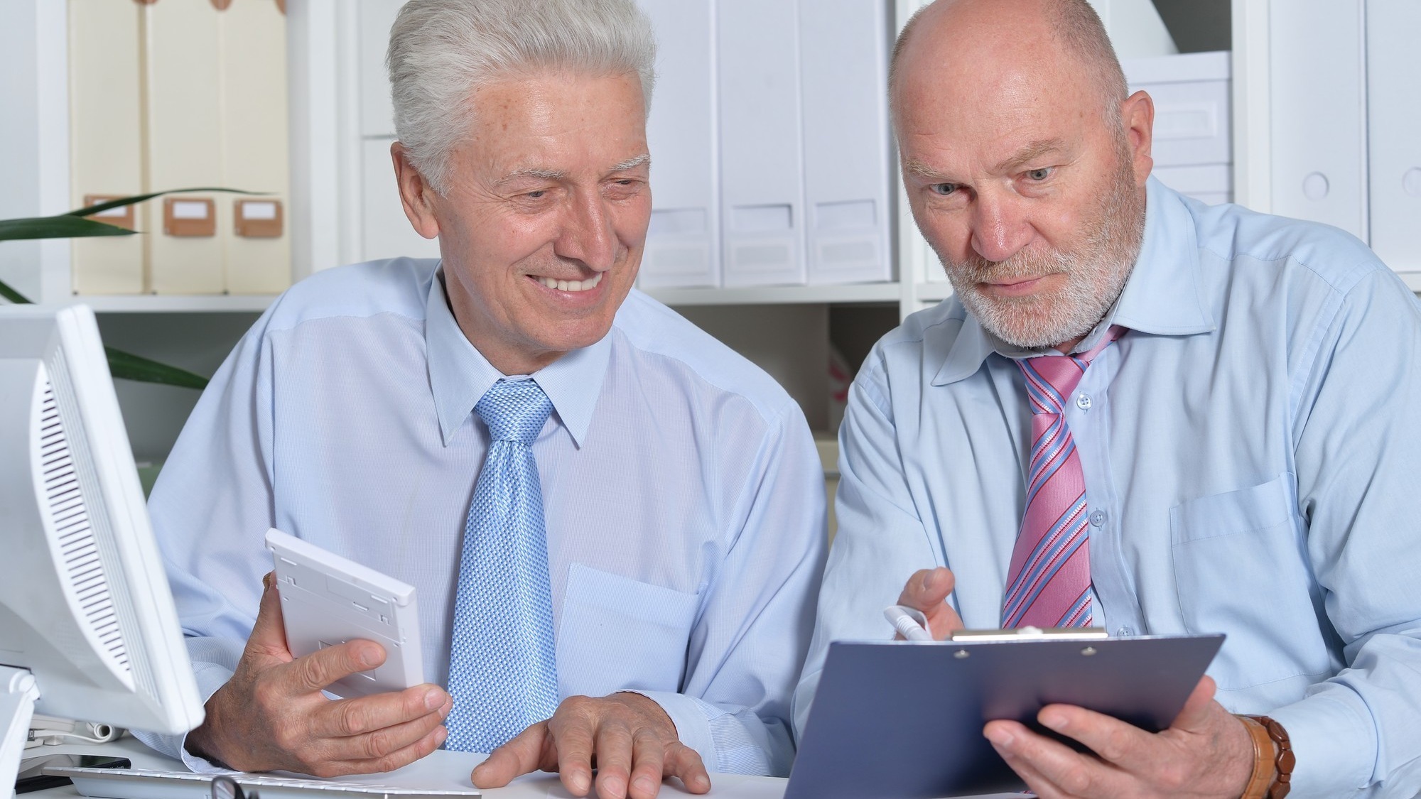 Portrait of two senior Business people working together with computer on the table