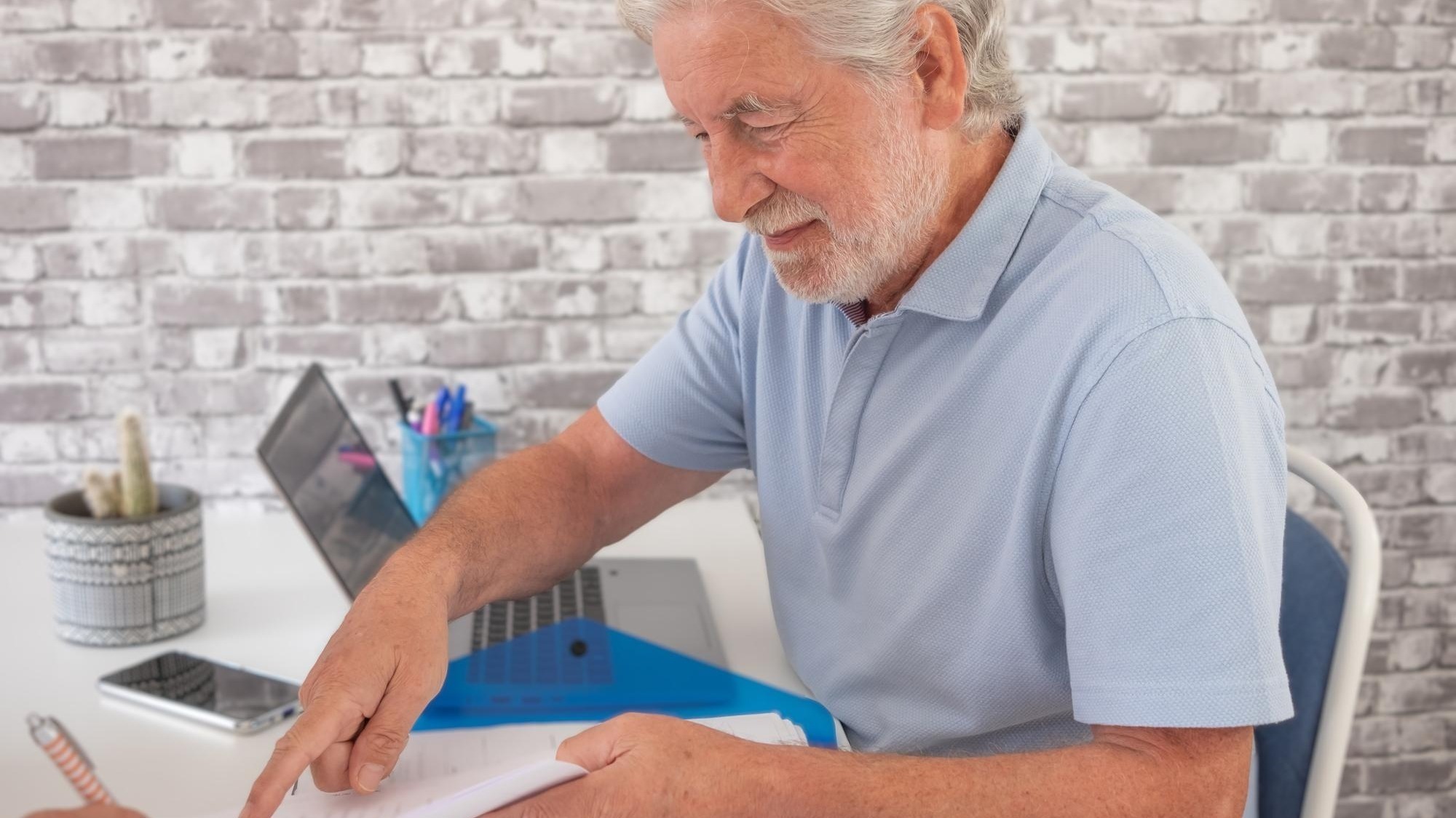 Handsome senior business man in office finishing the contract with a client asking for a signature smiling caucasian people sitting at the desk