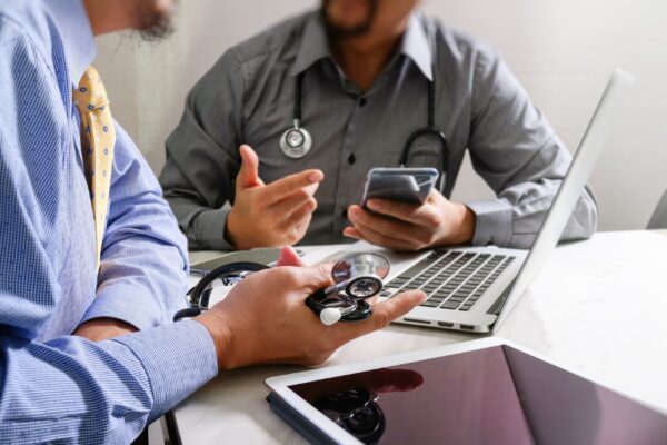 Doctor working with smart phone modern digital tablet laptop computer