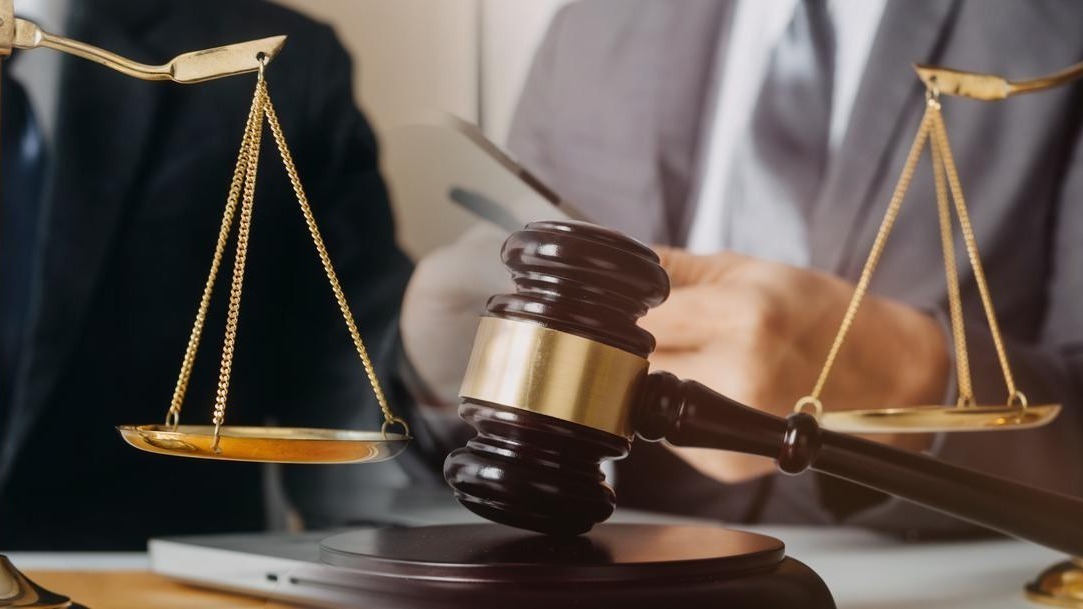 Business and lawyers discussing contract papers with brass scale on desk in office Law legal services advice justice and law concept picture with film grain effect
