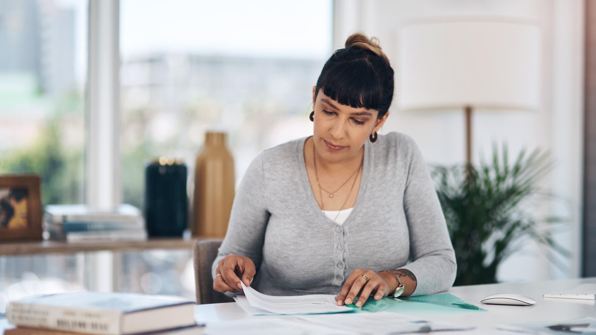 Files reading and woman in office with paperwork administration and checking research report Planning service and consultant at desk with insurance application registration folder or documents