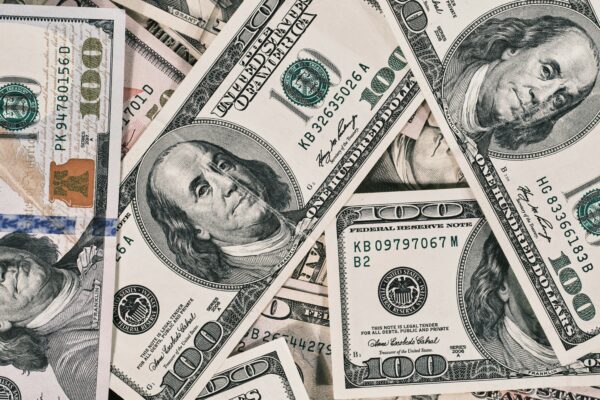 A scattered pile of American one hundred dollar banknotes