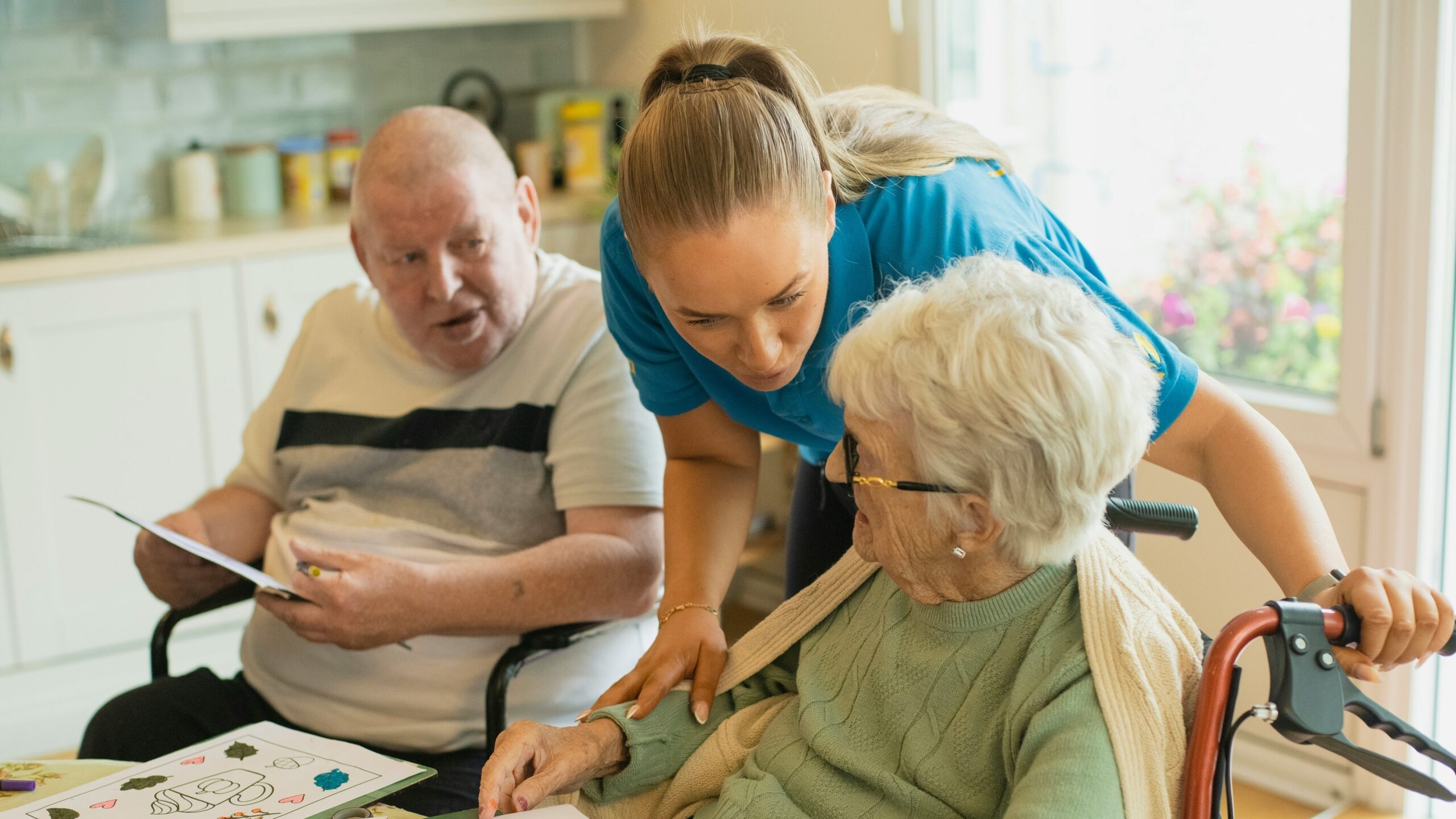 Caregiver assisting elderly couple with coloring