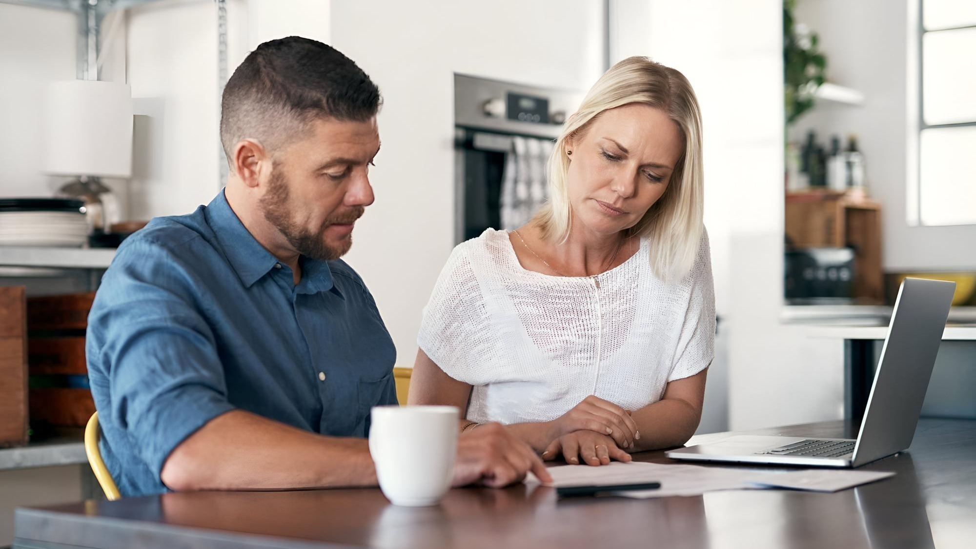 Cropped shot of young couple going through paperwork while doing their budget at home
