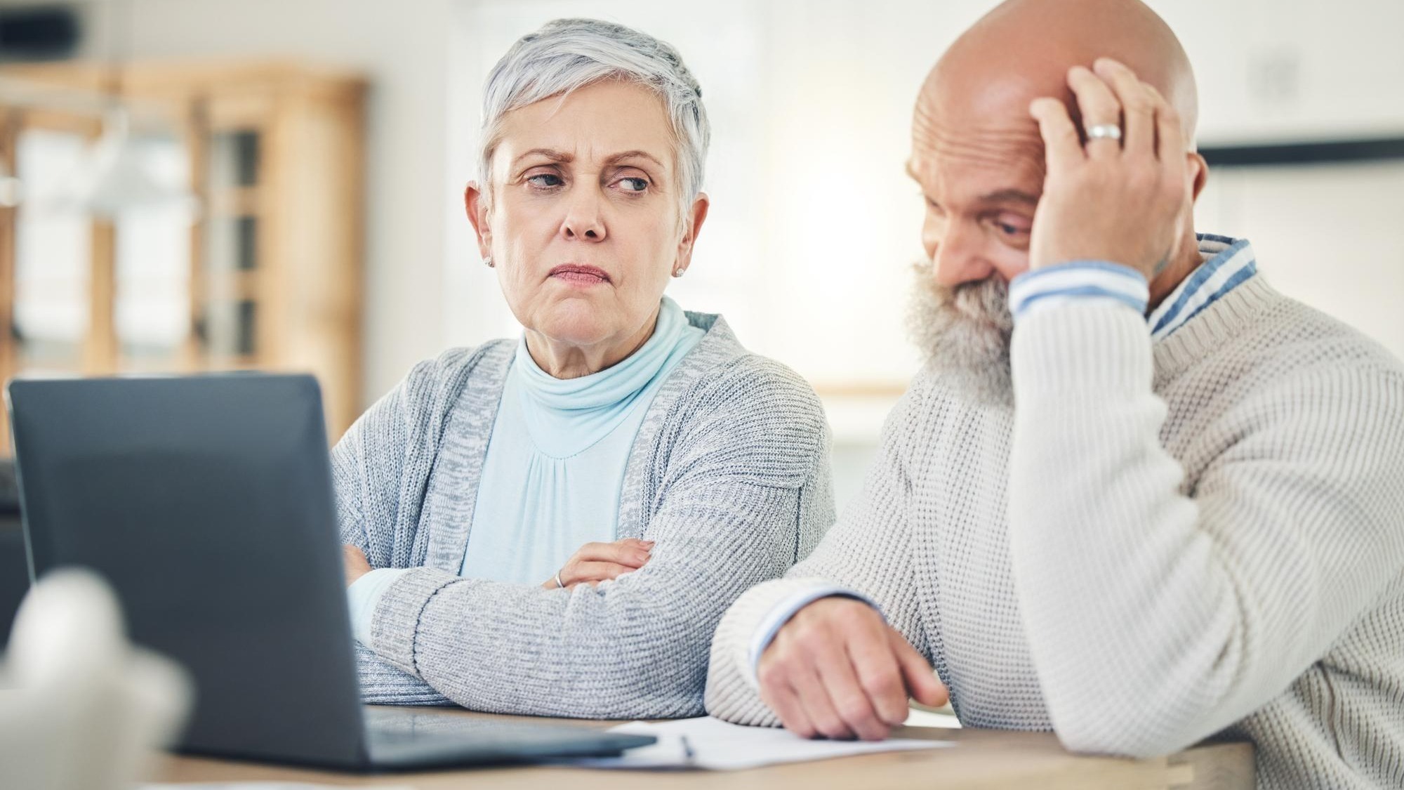 Laptop stress and budget with a senior couple feeling anxiety about their pension or retirement fund Computer debt finance or accounting with old people problem solving their savings or investment