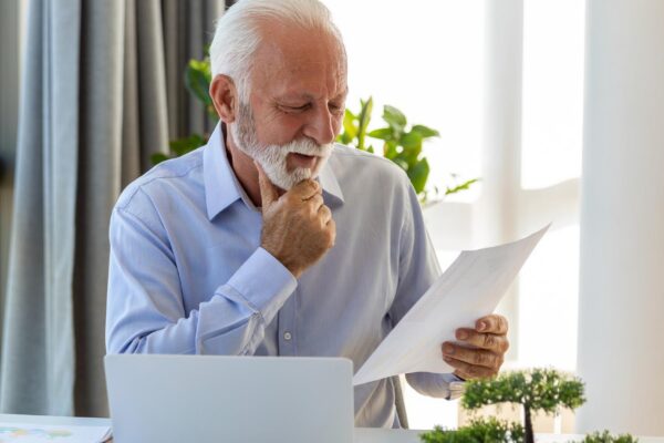 Financial advisor businessman using his laptop and doing some paperwork while sitting at desk and working