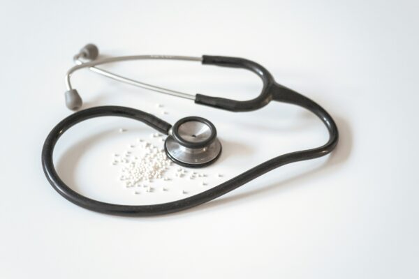 black and silver stethoscope on white surface