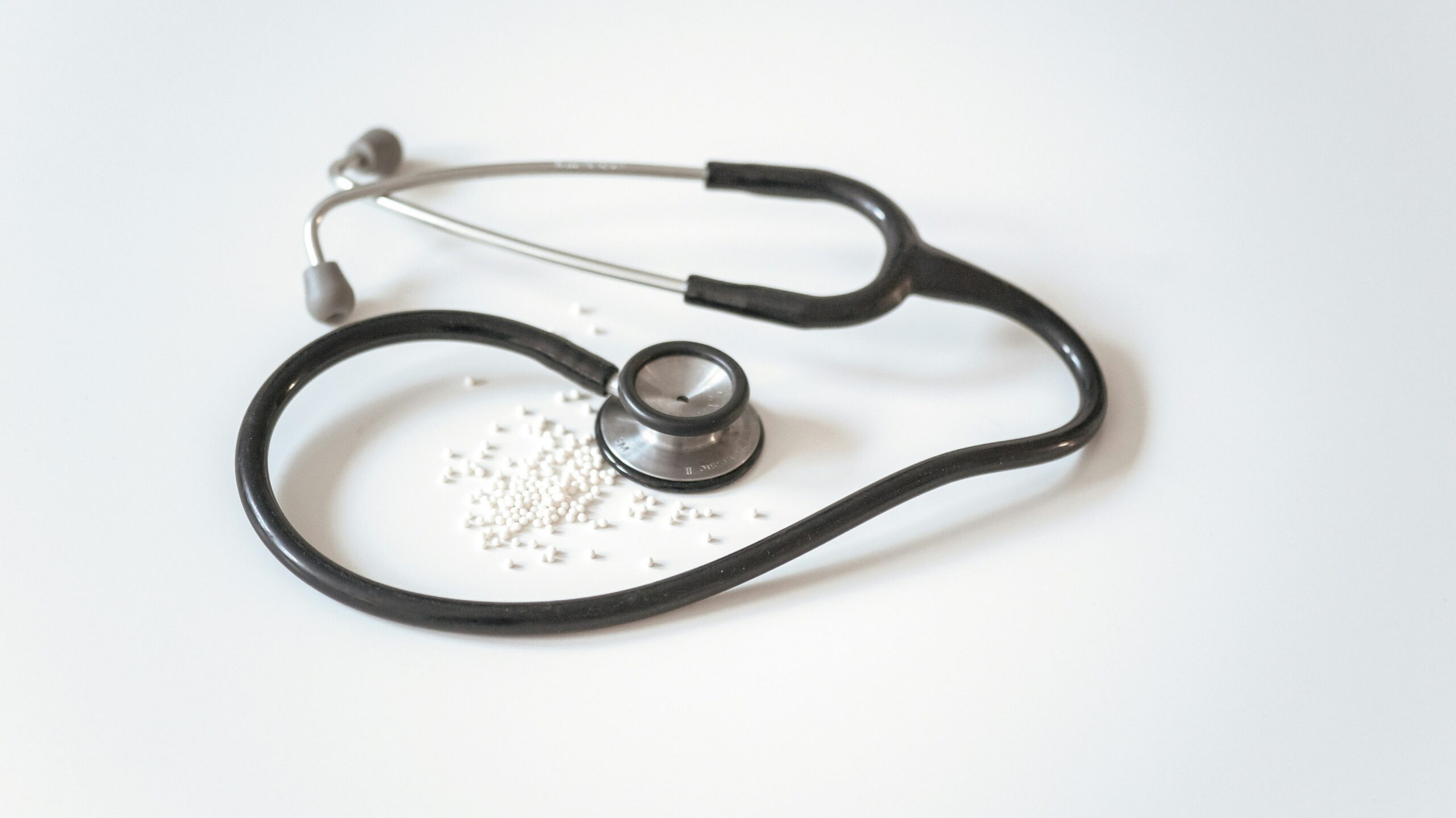 black and silver stethoscope on white surface