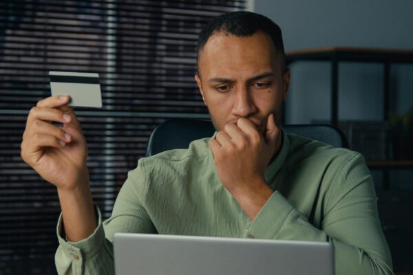 Puzzled confused african american man pay remote credit card using laptop problem with online payment bank failure annoyed guy male enter wrong password worried overspend money on electronic account