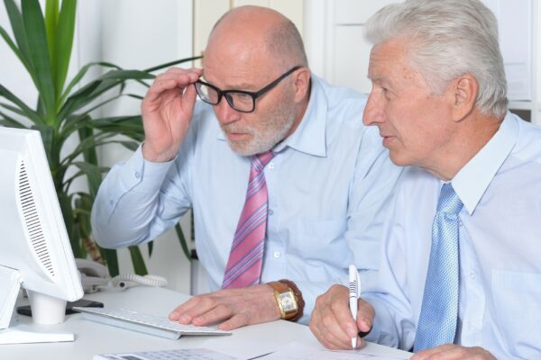 Portrait of two senior Business people working together with computer on the table