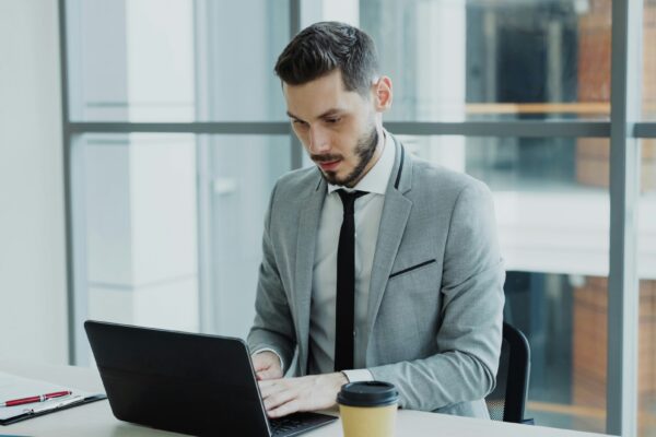 Man in suit working on a laptop at desk