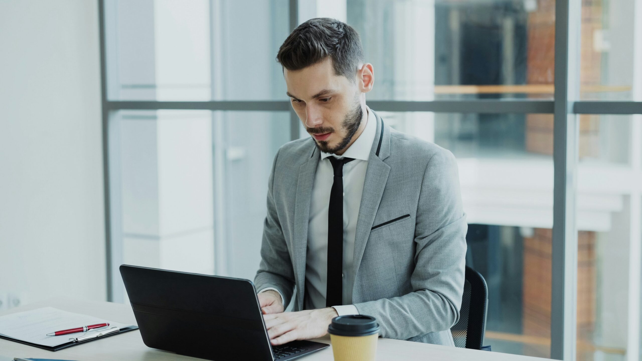 Man in suit working on a laptop at desk