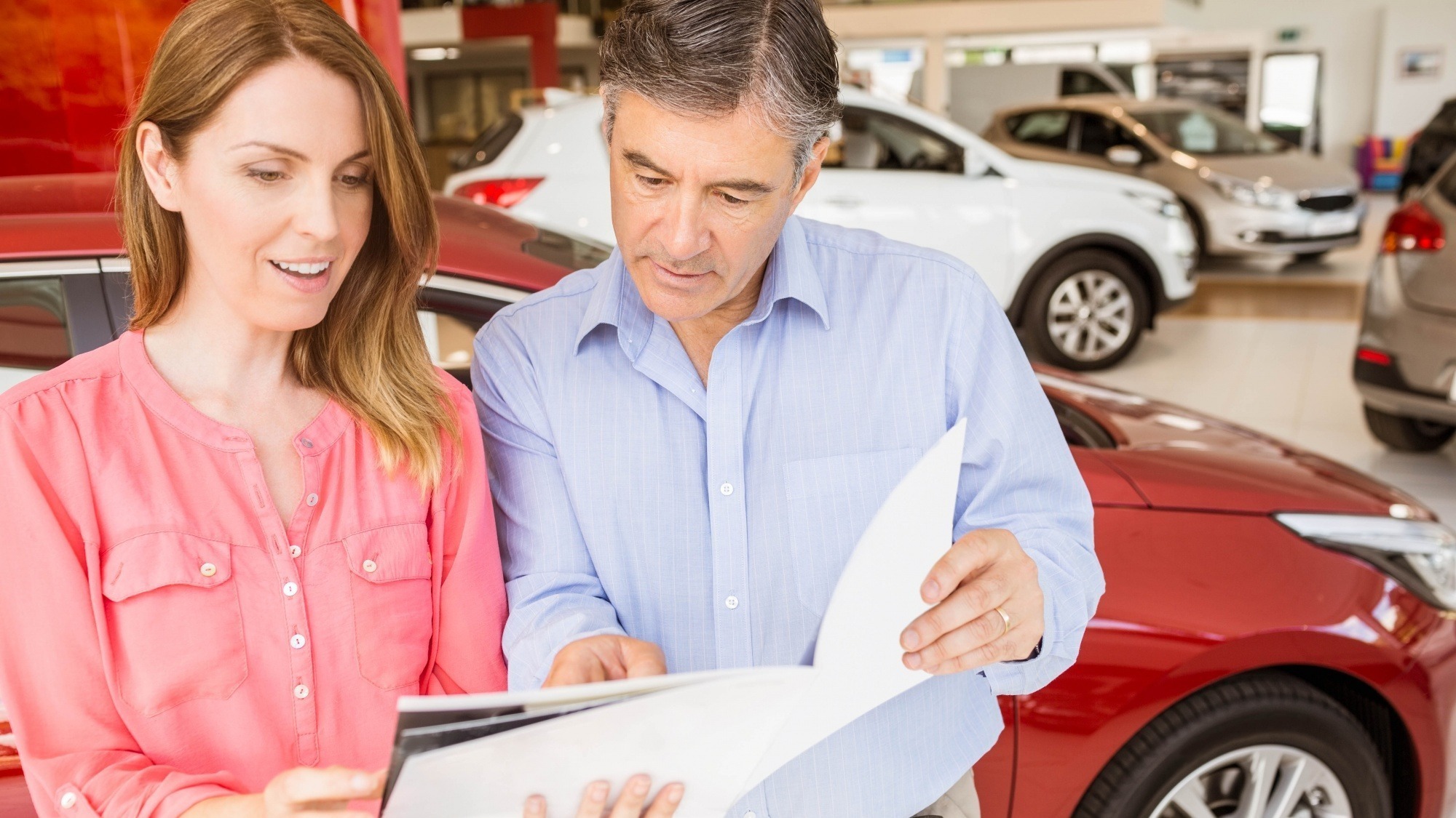 Smiling couple choosing the color of their new car