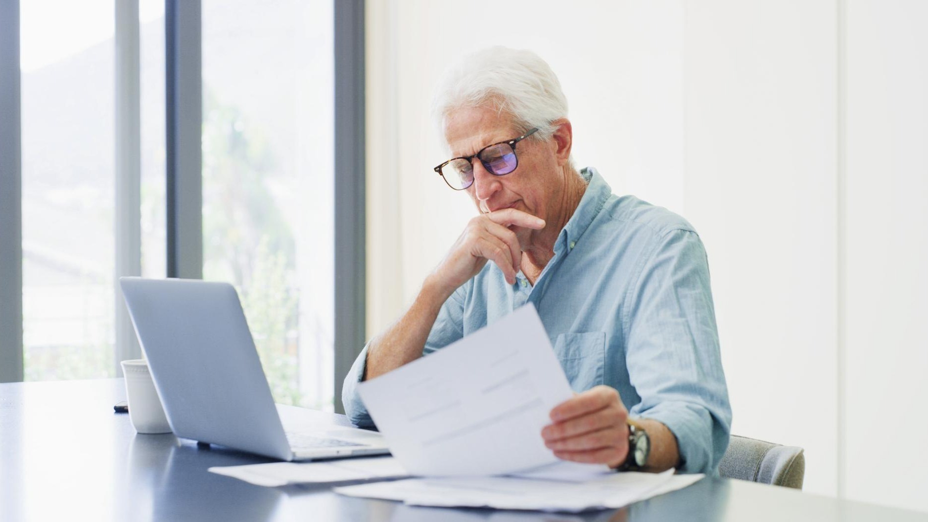 Laptop thinking and old man with documents financial analysis and bills with retirement fund Pc home and senior person with paperwork debt and asset management with insurance policy and decision