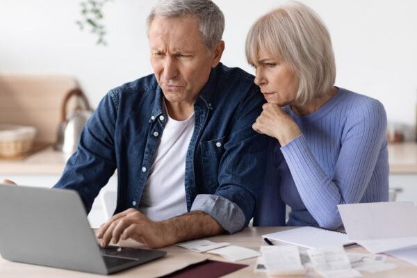 Confused senior husband and wife paying bills on Internet