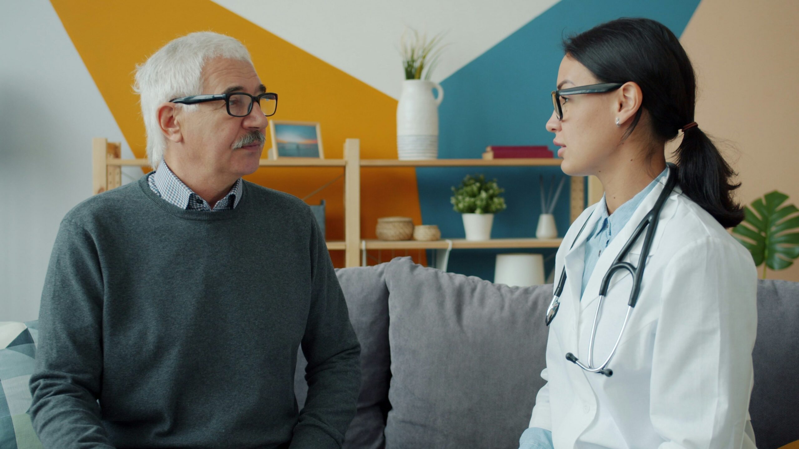 Doctor consults with an elderly patient on a couch