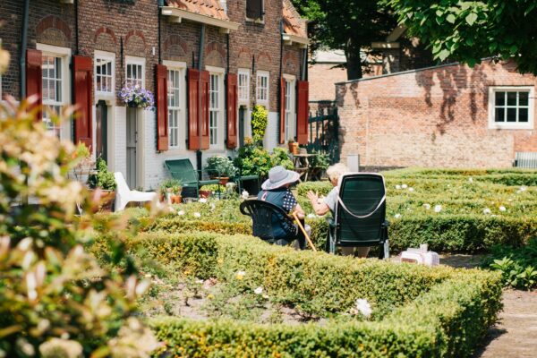 two woman sitting on chair near house at daytime
