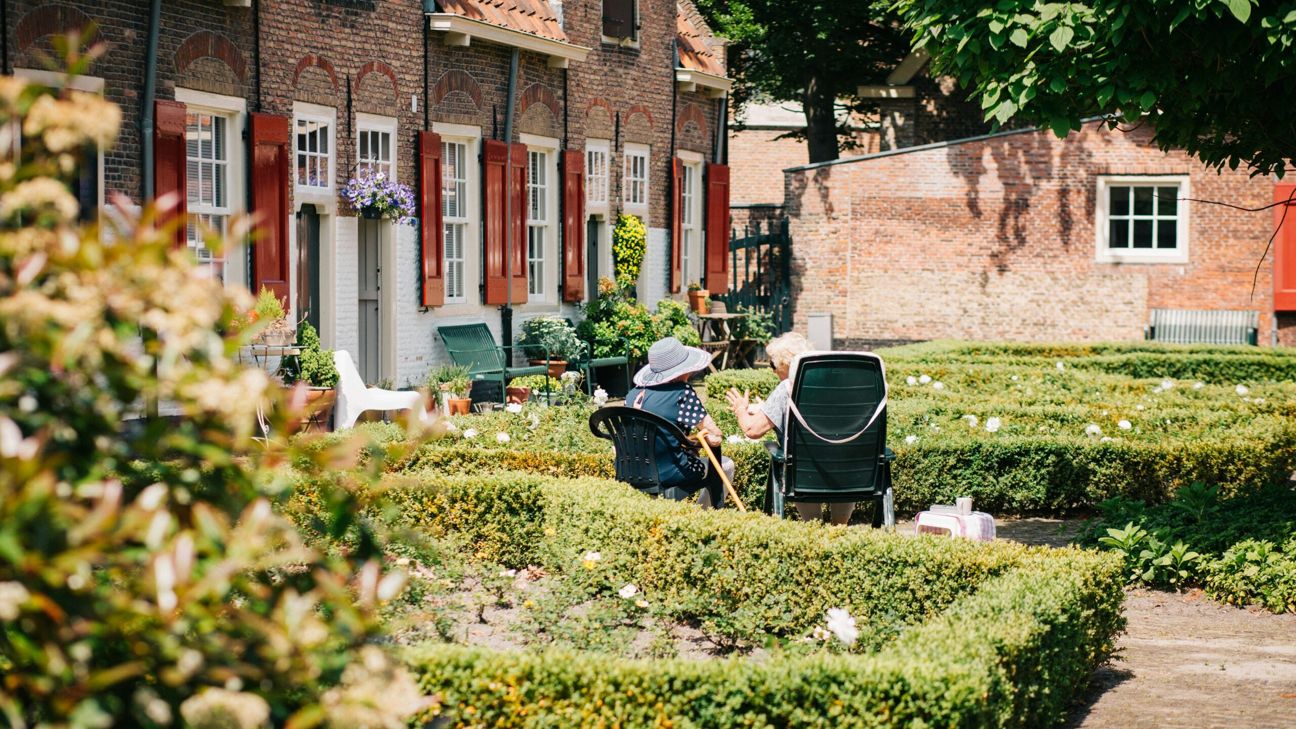 two woman sitting on chair near house at daytime