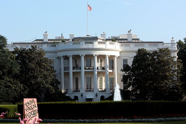 a pink protest sign in front of the white house