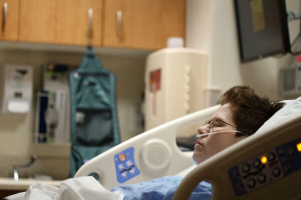 boy lying on beige recliner hospital bed