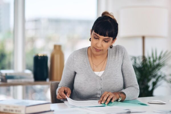 Files reading and woman in office with paperwork administration and checking research report Planning service and consultant at desk with insurance application registration folder or documents