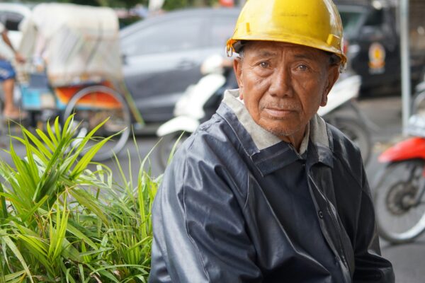 man in black jacket wearing yellow hard hat