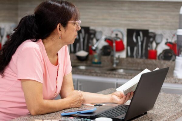 Reviewing finances Mature woman concentrating on the ledger for taxes