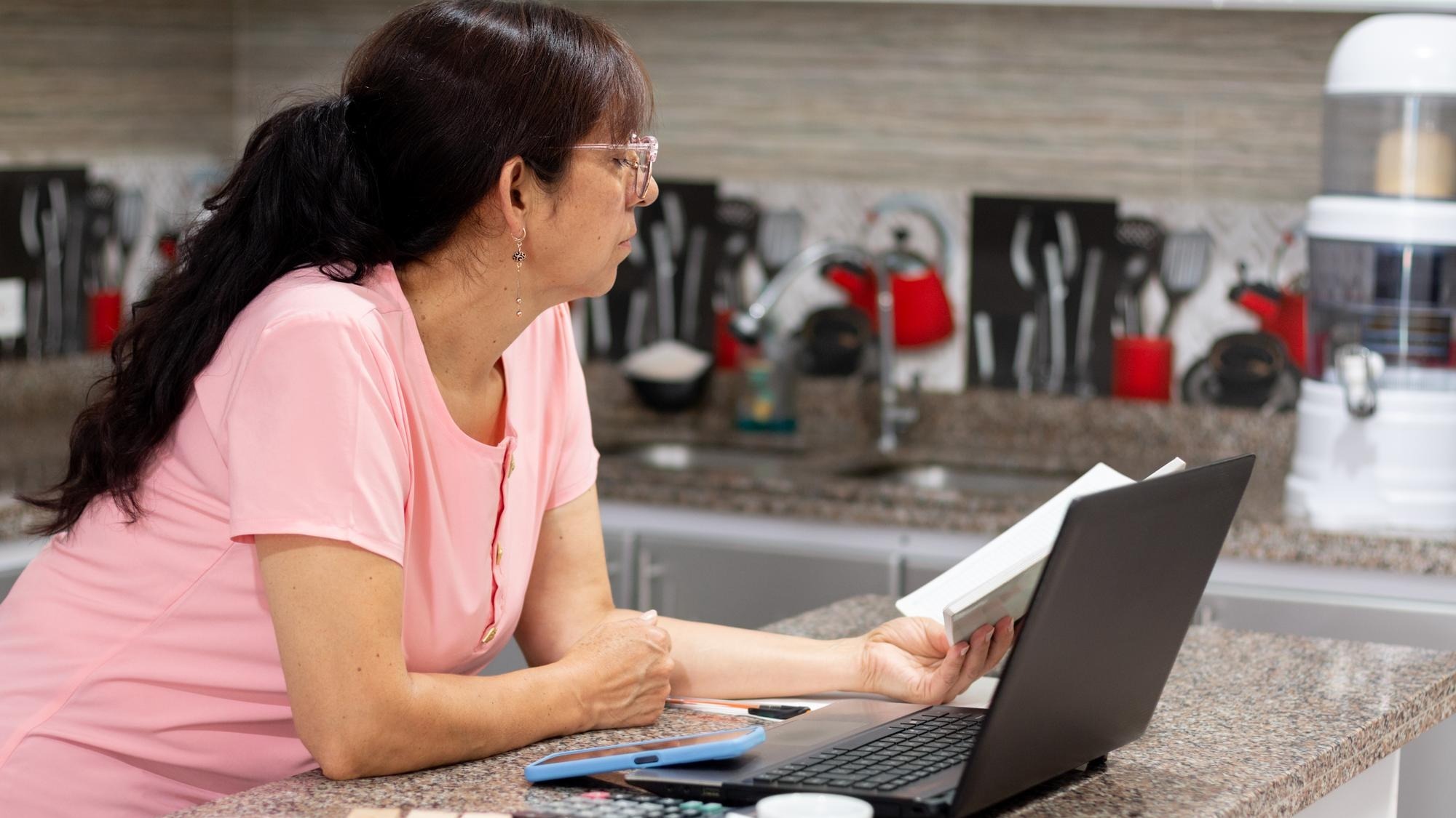 Reviewing finances Mature woman concentrating on the ledger for taxes