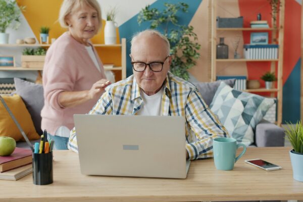 Elderly couple using a laptop in a living room