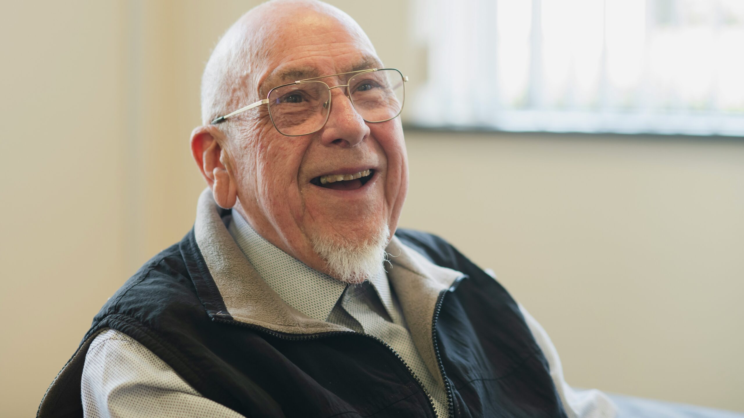 Happy, older man smiles broadly at the camera
