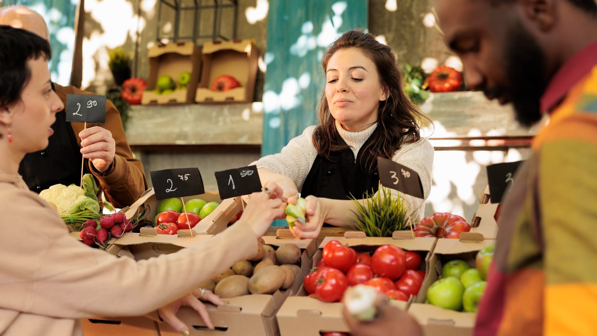 Diverse family couple tasting green apple varieties before buying fresh organic fruits and vegetables at farmers market. Farm produce stand owner offering free samples, bio natural products.