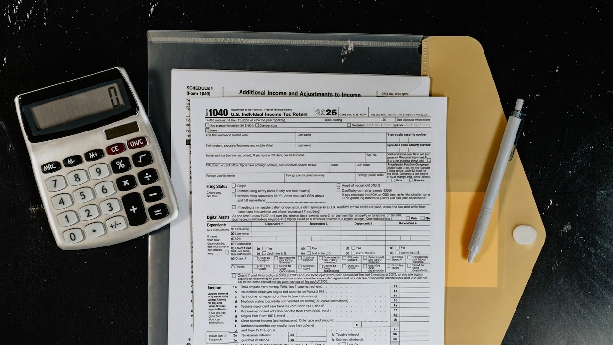 Calculator and tax forms on a dark surface