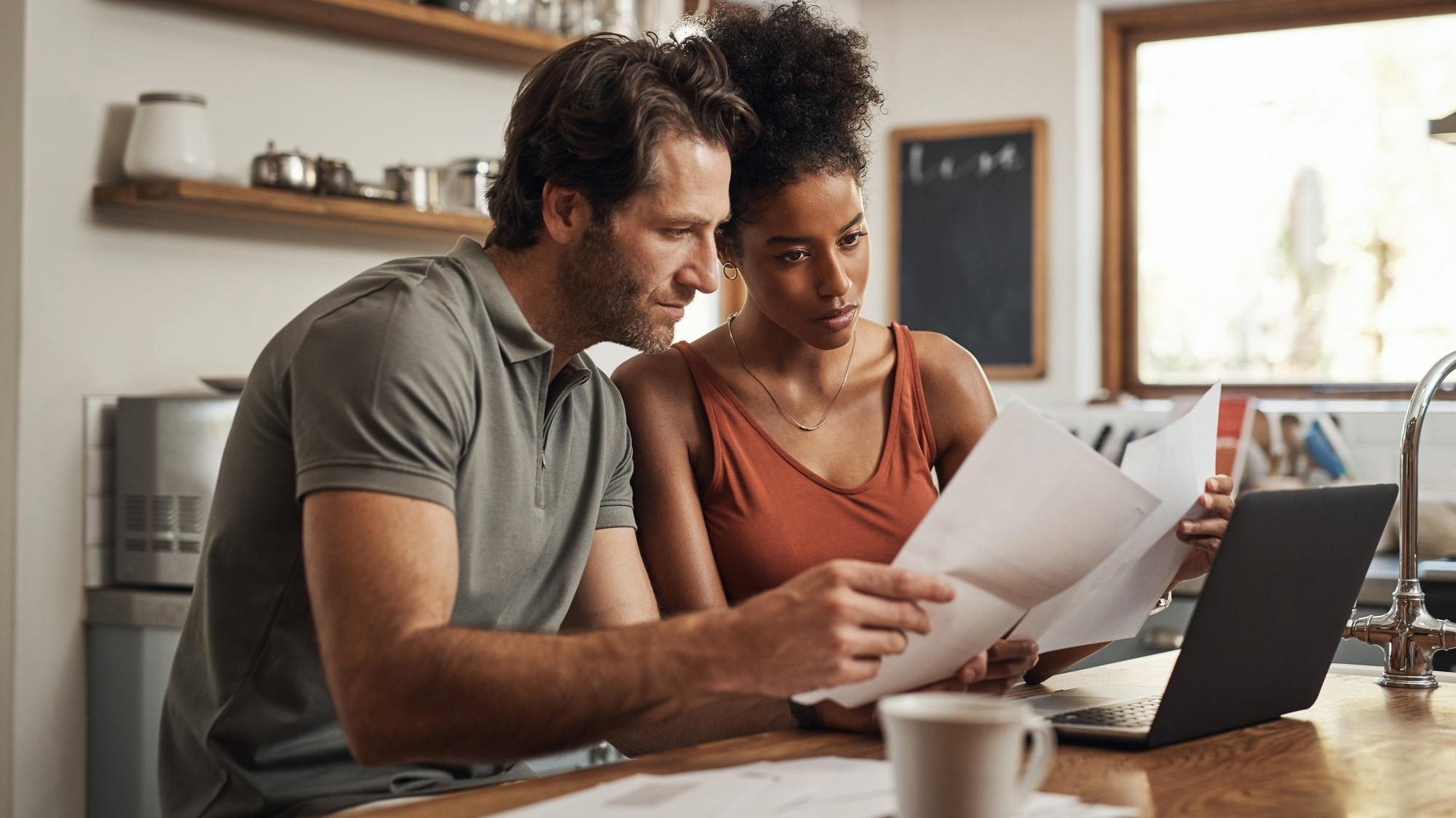 Its never too late to start Cropped shot of a couple using their laptop and going through paperwork at home